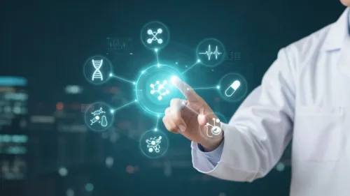 A scientist in a white lab coat pointing at a floating, circular digital interface displaying various medical and scientific icons against a blurred city background at night.