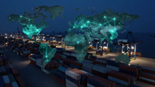 An overhead view of a shipping container port at night, overlaid with a glowing green digital network map of the world.